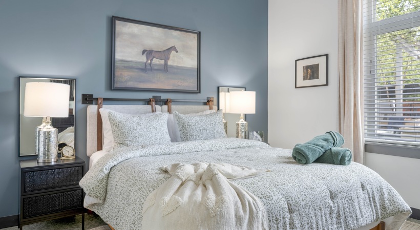 Bedroom with queen size bed, side tables with lamp.