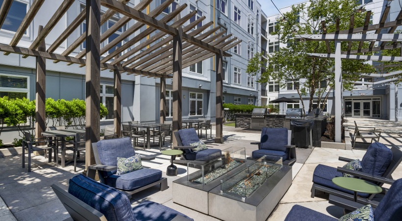 Courtyard with fire pit, lounge chairs, table and chairs, and BBQ grills